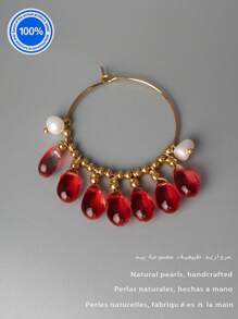 Un par de pendientes originales de perla. Estos pendientes exquisitamente diseñados presentan un aro dorado como Body principal. Enhebradas meticulosamente a lo largo del aro hay siete cuentas de cristal rojo natural con forma de gota. Acentuando estos, hay dos perlas barrocas, lo que crea un impresionante contraste con el ardiente atractivo de los cristales rojos.