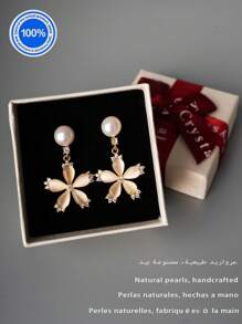 Um par [nova coleção de moda 2025] de brincos de pérolas originais Plata 925. Este requintado par de brincos apresenta um pino de pérola natural, suspendendo elegantemente uma silhueta inspirada em pétalas, trabalhada com cinco cristais meticulosamente polidos.