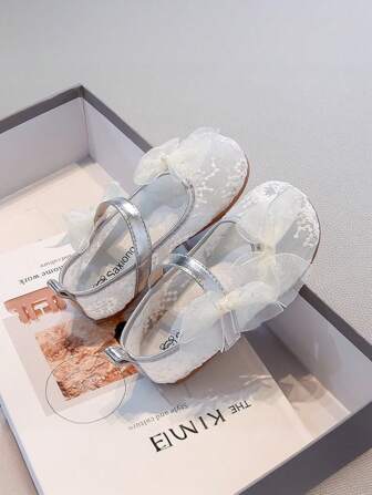 Een paar modieuze kinderschoenen van netgaas met strikversiering voor meisjes en studenten, sportschoenen voor volwassenen, geschikt voor de lente en de zomer.