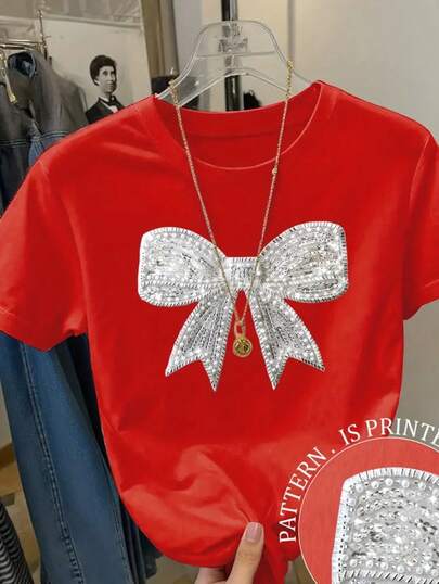 Camiseta básica para mujer de manga corta y cuello redondo con impresión de imitación de lentejuela con grafico de moño.