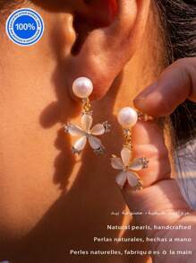 Um par [nova coleção de moda 2025] de brincos de pérolas originais Plata 925. Este requintado par de brincos apresenta um pino de pérola natural, suspendendo elegantemente uma silhueta inspirada em pétalas, trabalhada com cinco cristais meticulosamente polidos.