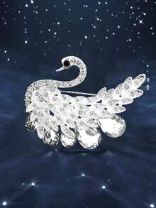 1枚优雅天鹅造型胸针，玫瑰金与红宝石交相辉映。精湛工艺展现细腻质感。天鹅象征着纯洁高贵，红宝石则增添了璀璨魅力，使其成为一件绝佳的时尚配饰。可用于服装配饰、衣服别针、包包饰物、背包饰物等。