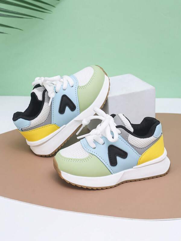 1 Pair Children's Sneakers. The Upper Is Made Of A Patchwork Of Green, Blue, Yellow, Gray, And Black Colors, Paired With White Shoelaces, Creating A Vibrant And Colorful Design. Some Areas Use Mesh Material For Breathability. There Is A Black Arrow-Shaped Decoration On The Side. The White Sole Has A Brown Front And Rear With A Textured Pattern To Improve Traction. The Overall Stylish And Sporty Design Is Suitable For Children's Daily Sports And Play.