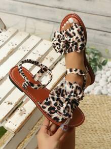 Nieuwe platte sandalen met een lieflijk en speels strikontwerp, casual resortstijl voor lente en zomer, geschikt voor tuinfeesten, stranden, wandelingen en dagelijkse uitstapjes. Verkrijgbaar in puur witte platte sandalen met strik, zwart-witte platte sandalen met luipaardstrik en bruin-zwarte platte sandalen met luipaardstrik.