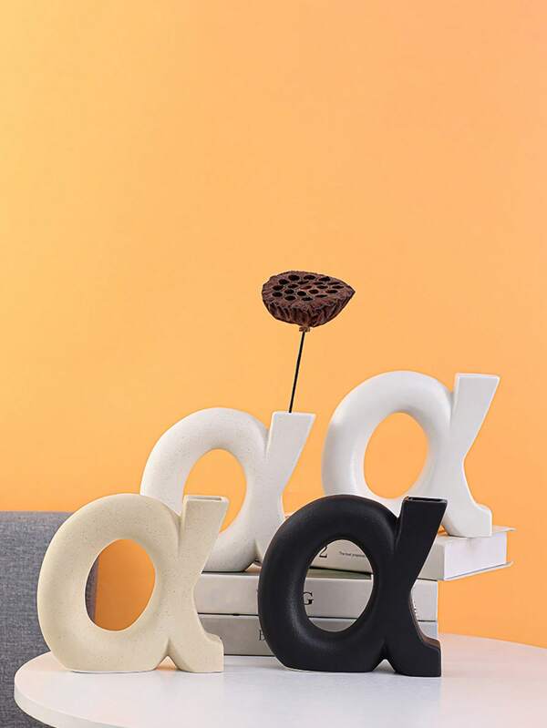 Un vase en céramique de style nordique avec une lettre, ornements de fleurs séchées, art géométrique, décorations d'intérieur créatives pour la maison, le salon. Décorations douces pour la pièce de vie