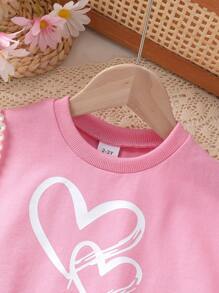 Set de 2 piezas de ropa informal y elegante para niñas, compuesto por sudadera de cuello redondo con gráfico de corazón y manga raglán de manga corta, y pantalones cortos, todo suave, transpirable y cómodo, adecuado para uso diario y vacaciones