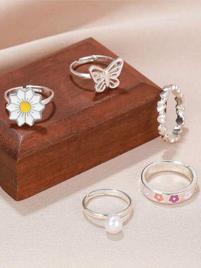 Set de 5 anillos ajustables con forma de perla, mariposa, margarita y corazón, un regalo ideal