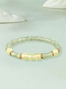 Una pulsera elástica de cuentas transparentes con cadena de bambú articulado, elegante y sofisticada, que simboliza la riqueza y la prosperidad. Adecuada para el uso diario, ocasiones de citas y un regalo pequeño y delicado.