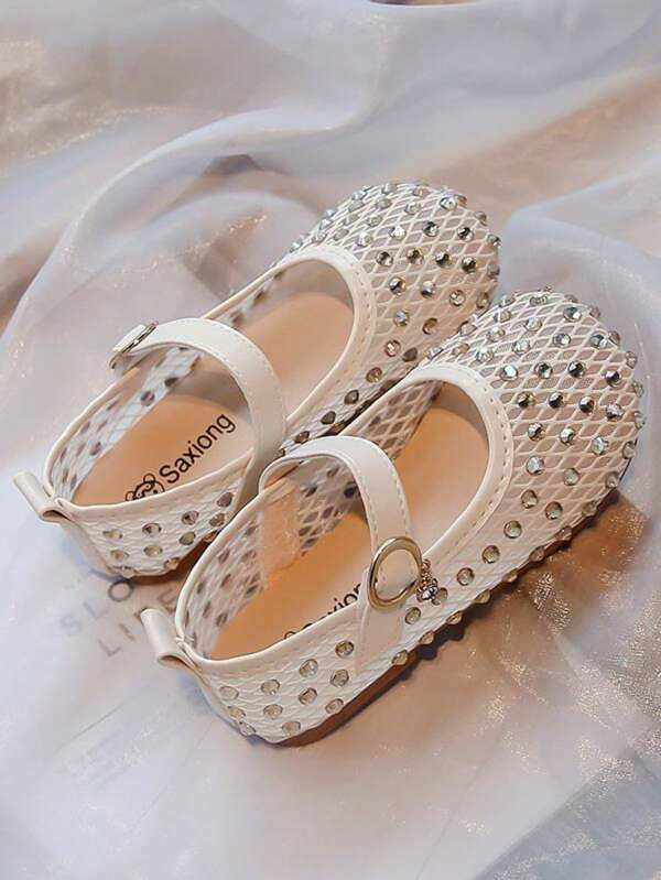 Un par de zapatos de princesa para niñas/niños talla grande vendidos, con un corte superior de malla hecho de diamantes de agua y hebillas beige (con anillos dorados y pequeños colgantes), con un estilo lujoso y dulce. Son adecuados para que las niñas de 3 a 12 años los usen en actuaciones, fiestas y otras ocasiones.