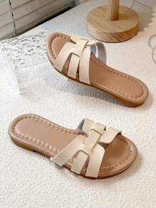 一双畅销儿童/简约风格女童人字拖，鞋面采用米色编织带设计，鞋底为浅棕色，适合日常休闲穿着
