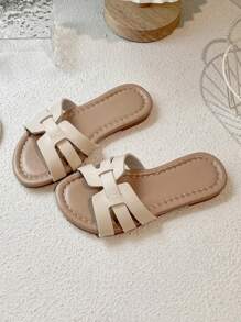 一双畅销儿童/简约风格女童人字拖，鞋面采用米色编织带设计，鞋底为浅棕色，适合日常休闲穿着