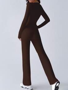 Completo sportivo da donna alla moda per l'autunno, top a maniche lunghe che scopre la pancia, pantaloni a zampa con lacci, aderente