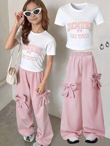 两件套时尚甜美女孩休闲套装，包括一件简约字母蝴蝶结装饰短袖上衣和一条粉色蝴蝶结装饰阔腿裤，适合春、秋、夏季、派对、上学和日常穿着，青少年适用。
