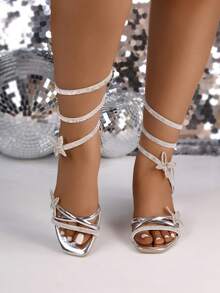 Zapatilla de moda para mujer con tacón de altura media y cuadrado, cómoda y con gran soporte, con acabado brillante tipo metálico, con aplicación de pedrería y elegante ajuste de cordón en espiral y  aplicaciones de mariposas brillantesque estilizan la figura del pie y bandas metálicas en empeine, ideales para eventos formales o casuales, fiestas elegantes, cenas, bodas, graduaciones, ofreciendo un toque de estilo y glamour. Estos zapatos pertenecen a estilos clásicos y atemporales que resaltan la sofisticación en el calzado femenino. - Plateado - Ver 3