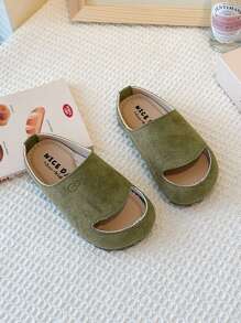 Este es un par de chanclas para niños con puntera. El estilo es de una sola pierna y el material de la parte superior parece ser de ante. La suela es gruesa. Este calzado unisex para niños pertenece a la edición coreana minimalista del verano de 2025.