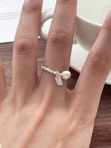 Un anillo de plata pura S925 de perla natural rota para mujeres, con una etiqueta colgante de la suerte y un anillo elástico de cuerda