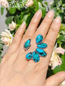 这款复古西部乡村风格的做旧银色仿绿松石花朵戒指，采用美式复古开口设计。戒指以做旧银色为底，镶嵌蓝绿色纹理仿绿松石，组成立体花朵造型，边缘饰以复古铆钉纹理。融合了美式西部/乡村和复古风格，兼具天然石材的质感和做旧金属工艺，散发出粗犷不羁的气息，是西部风格造型的完美点缀。 - 開口松石戒指 - 查看 3