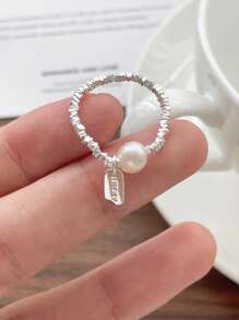 Un anillo de plata pura S925 de perla natural rota para mujeres, con una etiqueta colgante de la suerte y un anillo elástico de cuerda
