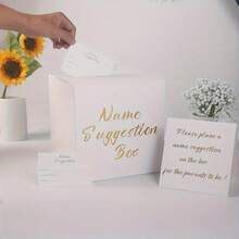 Zestaw pudełek na propozycje imion ze złotą folią, w tym karta ekspozycyjna i 30 kart do głosowania. Idealne na wesela, baby shower, urodziny, rocznice, imprezy z okazji ujawnienia płci dziecka. Wykonane z eleganckiego białego papieru
