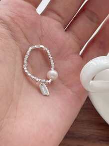 Un anillo de plata pura S925 de perla natural rota para mujeres, con una etiqueta colgante de la suerte y un anillo elástico de cuerda