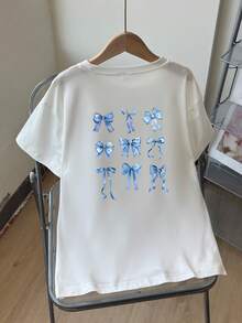 一件女童休闲图案宽松T恤，饰有蝴蝶结，甜美风格，适合春夏户外活动和玩耍的短袖上衣