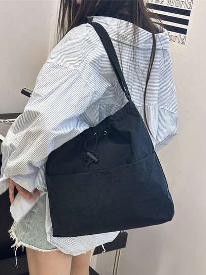 1个极简水桶形斜挎包，可调节肩带，抽绳封口，轻盈透气的尼龙材质，纯色设计，适合男女日常通勤和街头穿搭