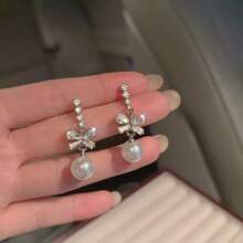 1 paire de boucles d'oreilles élégantes de style boutique avec un nœud papillon et un design de fausse perle. Chic pour les dames, convient pour un port quotidien