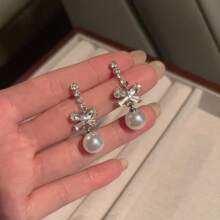 1 paire de boucles d'oreilles élégantes de style boutique avec un nœud papillon et un design de fausse perle. Chic pour les dames, convient pour un port quotidien