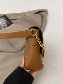 女士黑色皮革单肩包，金色链条和锁扣装饰，优雅的晚装斜挎包