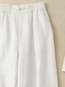 女士简约舒适休闲透气弹力腰亚麻长裤，适合春夏秋季节穿着。裤子饰有手工缝制纽扣。