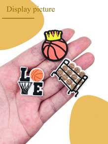 24 piezas de la Serie de Premios Grandes de Locura del Baloncesto, accesorios de moda desmontables y lavables, cada paso brilla con estilo. Calzado de PVC con tema de baloncesto, que incluye elementos como balones de baloncesto, canastas, corazones, trofeos, etc., así como palabras como "AMAR" y "VIVIR AMAR JUGAR".