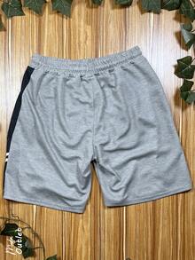Short casual y deportivo para hombre, estampado de dos líneas pequeñas en los laterales de la prenda, talle de cintura natural con cordón y ajuste de pierna suelto, bolsillos funcionales con cierre para mayor seguridad, tela de poliéster y elastano, apto para temporadas de primavera y verano, muy fresco y cómodo, ideal para hacer deporte o el uso casual. - Gris - Ver 2