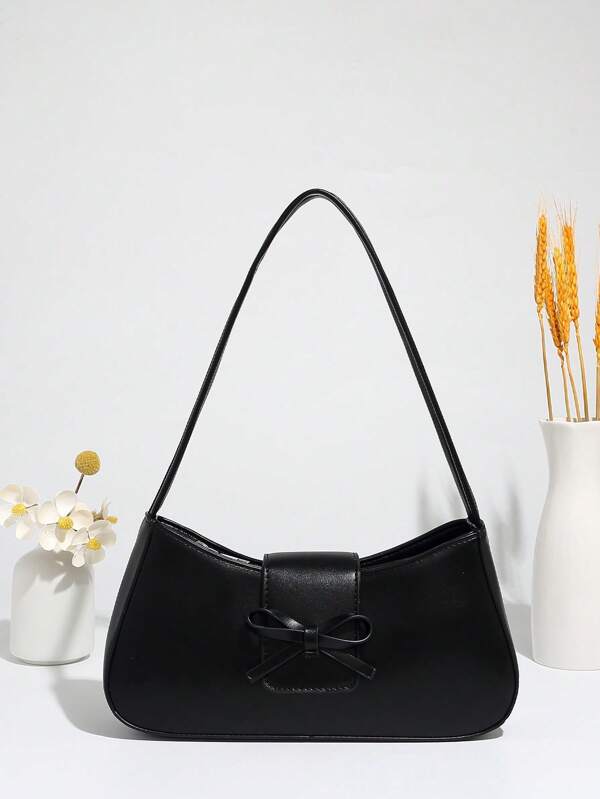 Una bolsa de hombro minimalista de estilo callejero con un lazo delantero, diseñada como una bolsa de transporte debajo del brazo.
