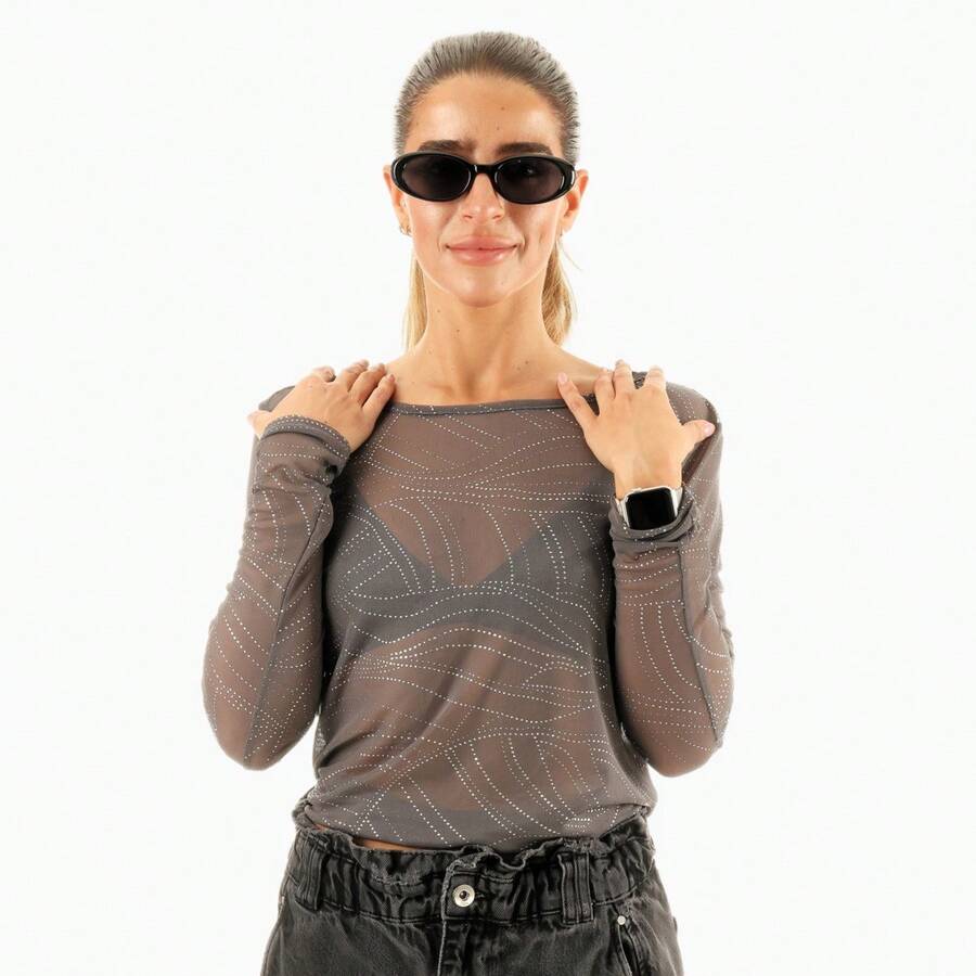 Blusa transparente con diseño lurex y efecto brillante, de manga larga y ajuste ceñido, ideal para looks elegantes y modernos. Perfecta para combinar con prendas básicas y destacar en ocasiones nocturnas. Su estilo sofisticado resalta la silueta, siendo adecuada para eventos especiales y outfits glamorosos. Una pieza versátil que añade un toque de distinción a cualquier guardarropa - Gris - Ver 1