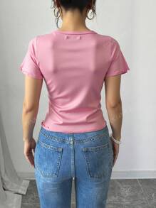 Blusa  de canalé con moño de pedrería, manga corta y acabado ondulado – Moda 2025