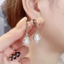 A Pair Of Teardrop Turmeric Petal Cat's Eye Earrings, Exquisitely Crafted, Exudes The Charm Of A Lady And Is A Suitable Jewelry Item For Women To Wear On A Daily Basis