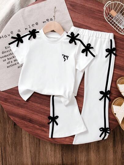 Girls Cute Ballet Bowknot Black Tee + Flare Pants Set, With Playful Pink Bow Accent On Shoulders, Simple Yet Vibrant. Coordinating Bow Decor On Pants Sides, Fashionable And Eye-Catching. Suitable For Daily Outings, Gatherings With Friends, Easily Creating A Sweet & Spicy Look.