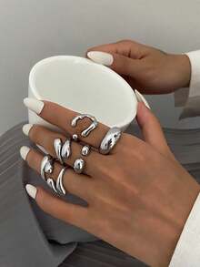 6pcs/Set Vintage Minimalist Alloy Molten Lava Teardrop Design Open Rings, Asymmetrical Fashionable Thick Metal Gold Tone Ring Set, Irregular Drops Of Liquid Metal Drape Over The Ring, Its Surface Replicating The Etched Texture Of Waves, With A Cold Sea Spray Luster On The Electroplated Silver Background. The Glazed Droplets Are Embedded With A Bubble Pattern, A Blue And White Gradient That Resembles The Crashing Waves Of The , And A Crescent-Shaped Indentation Hidden In The Ring's Opening And Closing Points. When The Fingertip Shakes, The Cut Surface Reflects The Shimmering Waves, As If Wearing The Instantly Frozen Waves On The Finger, The Gentle And Rigid Design Allows A Sense Of Niche And A Sense Of Art To Coexist.Suitable For Women's Daily Commute,Perfect Gift For Birthdays, Holiday Gifts, And Parties. Suitable For Daily Wear And Holiday Celebrations, Suitable For All Seasons, And Is An Ideal Choice For Holiday Accessories. - 銀色 - 查看 1
