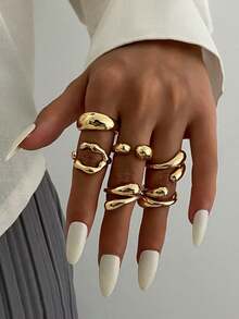 6pcs/Set Vintage Minimalist Alloy Molten Lava Teardrop Design Open Rings, Asymmetrical Fashionable Thick Metal Gold Tone Ring Set, Irregular Drops Of Liquid Metal Drape Over The Ring, Its Surface Replicating The Etched Texture Of Waves, With A Cold Sea Spray Luster On The Electroplated Silver Background. The Glazed Droplets Are Embedded With A Bubble Pattern, A Blue And White Gradient That Resembles The Crashing Waves Of The , And A Crescent-Shaped Indentation Hidden In The Ring's Opening And Closing Points. When The Fingertip Shakes, The Cut Surface Reflects The Shimmering Waves, As If Wearing The Instantly Frozen Waves On The Finger, The Gentle And Rigid Design Allows A Sense Of Niche And A Sense Of Art To Coexist.Suitable For Women's Daily Commute,Perfect Gift For Birthdays, Holiday Gifts, And Parties. Suitable For Daily Wear And Holiday Celebrations, Suitable For All Seasons, And Is An Ideal Choice For Holiday Accessories. - 金黃色 - 查看 1