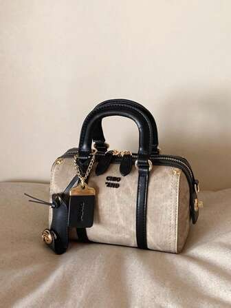 时尚新款女士半熟摩卡枕头包，采用PU面料制成，配有独立肩带，饰有金属挂饰和吊牌装饰。这是一款优雅的女士手提包和单肩斜挎包，质感高端，适合通勤、聚会、购物。