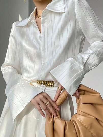Camisa elegante de dama con cuello de camisa de satén blanco a rayas, mangas largas, puños y decoración de botones, para inicios del otoño