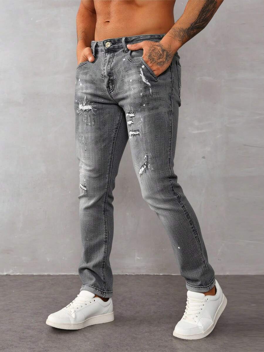 Jeans skinny para hombre en denim gris claro, con detalles rotos y salpicaduras de pintura, estilo urbano y moderno - Gris - Ver 1