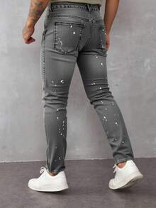 Jeans skinny para hombre en denim gris claro, con detalles rotos y salpicaduras de pintura, estilo urbano y moderno - Gris - Ver 2