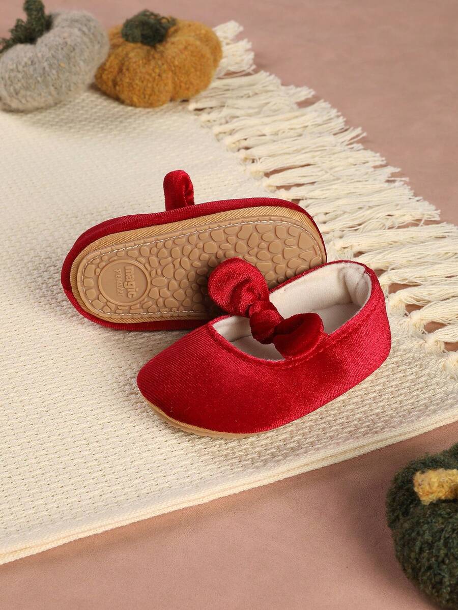 一双可爱毛绒百搭红色平底鞋，带蝴蝶结和搭扣，是新年和圣诞节的理想之选