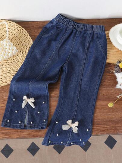 年轻女孩牛仔微喇叭牛仔裤，时尚仿珍珠和蝴蝶结装饰开叉下摆 7/8 长裤
