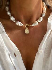 قلادة باروك فاخرة وأنيقة مزينة باللؤلؤ مع قلادة حرف أولي للنساء. قلادة الحرف الأولي هذه راقية وجذابة، مناسبة كهدية جميلة للنساء في المناسبات.