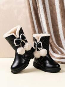 儿童冬季雪地靴，配有毛绒衬里、绗缝图案、蝴蝶结装饰和绒球细节