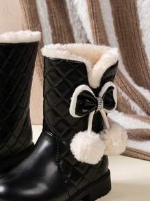 儿童冬季雪地靴，配有毛绒衬里、绗缝图案、蝴蝶结装饰和绒球细节