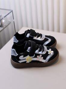 زوج من أحذية الأطفال الرياضية للتزلج بتطريز أسود للبنات