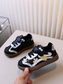 زوج من أحذية الأطفال الرياضية للتزلج بتطريز أسود للبنات